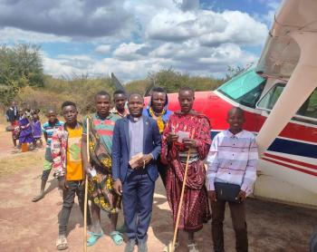 Group gathers in front of plane