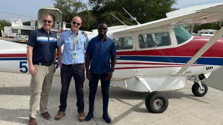 Alf Rhea (left) and Calvin Andrew (right) ready to board the Cessna 206 with MAF Pilot Peter Griffin (middle) at Kilimanjaro International Airport.