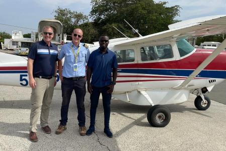 Alf Rhea (left) and Calvin Andrew (right) ready to board the Cessna 206 with MAF Pilot Peter Griffin (middle) at Kilimanjaro International Airport.