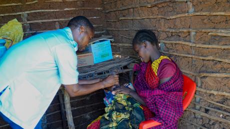 A nurse administering polio vaccine drops to an infant.