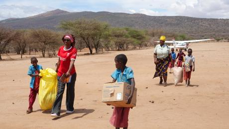 Children supporting nurses to carry stuff to the clinic